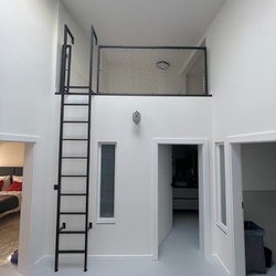 Moderné kovové zábradlie s rebríkom zabezpečí využitie priestorov vo vysokých miestnostiach Moderné kovové zábradlie s rebríkom zabezpečí využitie priestorov vo vysokých miestnostiach