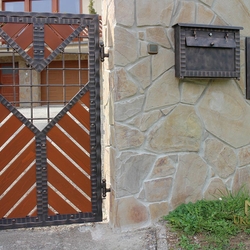 A modern post box in harmony with a fence A modern post box in harmony with a fence